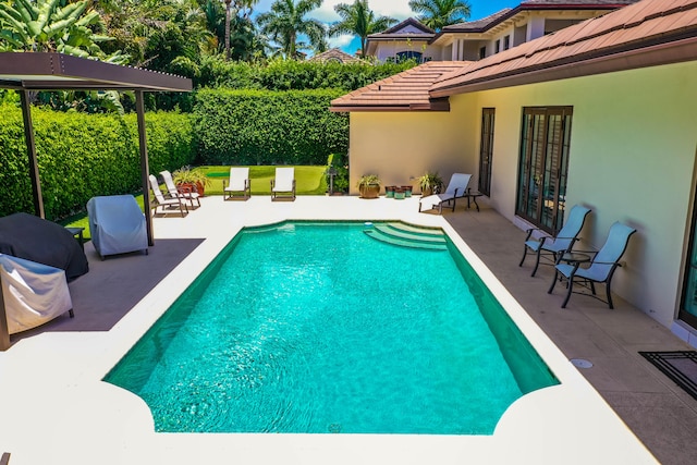 view of swimming pool with a patio and french doors