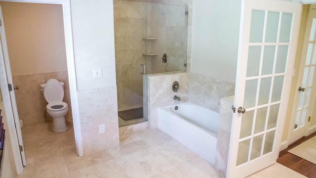 bathroom with tile flooring, toilet, and separate shower and tub