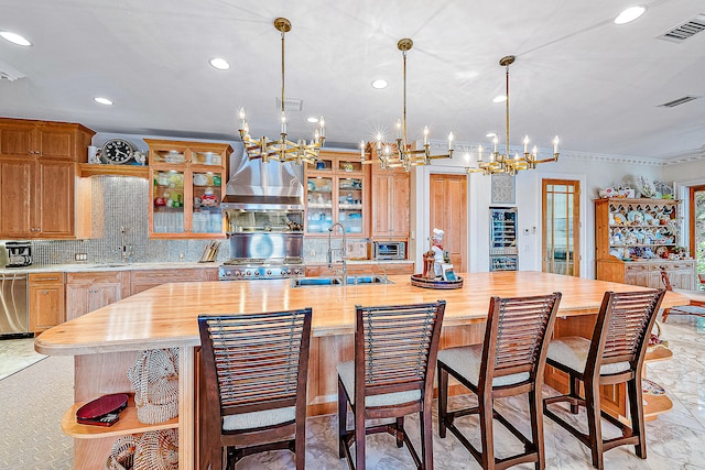 kitchen featuring light tile flooring, a center island with sink, a chandelier, and sink