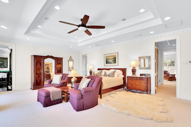 carpeted bedroom featuring ceiling fan, a tray ceiling, and ornamental molding