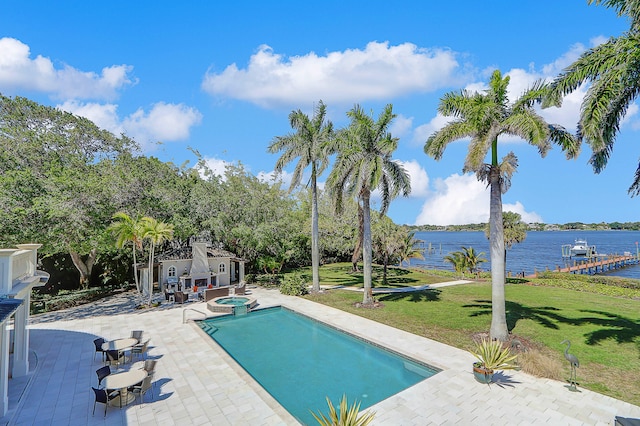 view of swimming pool featuring a water view, a yard, and a patio