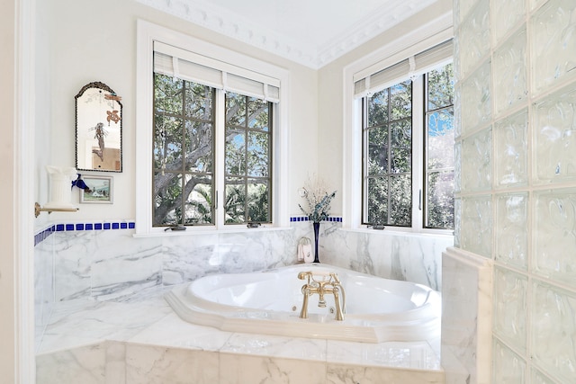 bathroom with ornamental molding and tiled bath