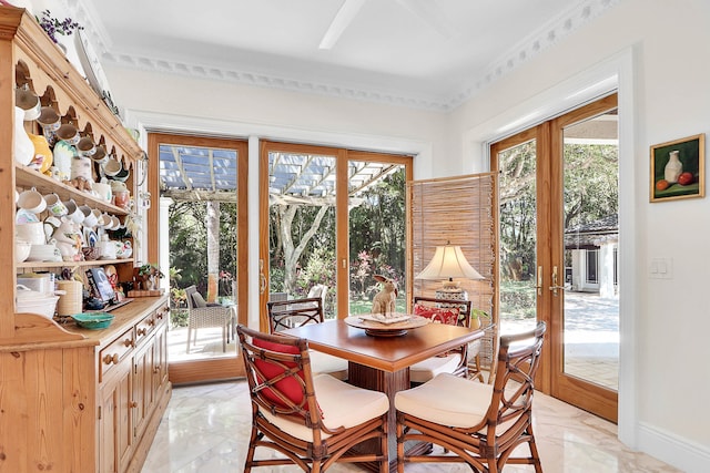 tiled dining space featuring french doors and crown molding