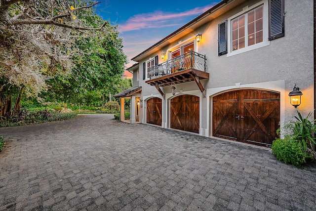 view of front of home featuring a garage and a balcony