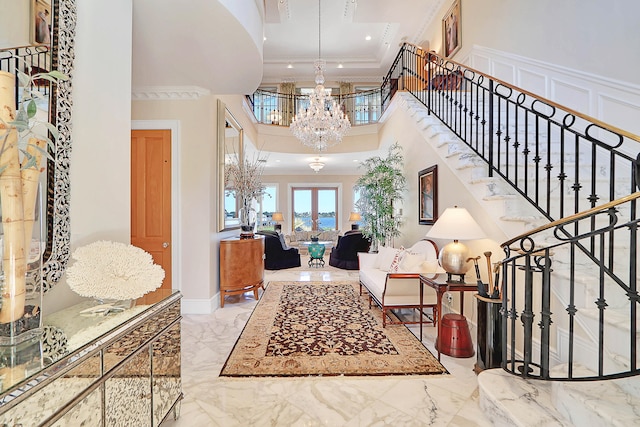 tiled entryway with ornamental molding, a notable chandelier, and a high ceiling