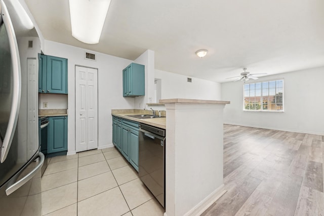 kitchen with stainless steel refrigerator, black dishwasher, light wood-type flooring, ceiling fan, and blue cabinetry