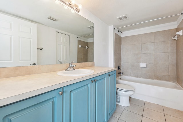 full bathroom featuring tile floors, tiled shower / bath combo, toilet, and vanity