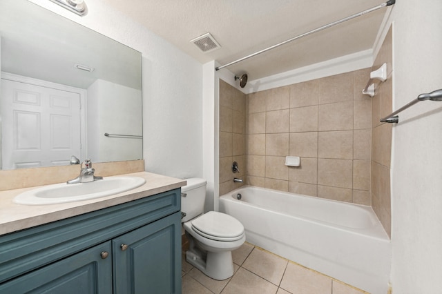 full bathroom featuring toilet, tiled shower / bath, a textured ceiling, large vanity, and tile floors