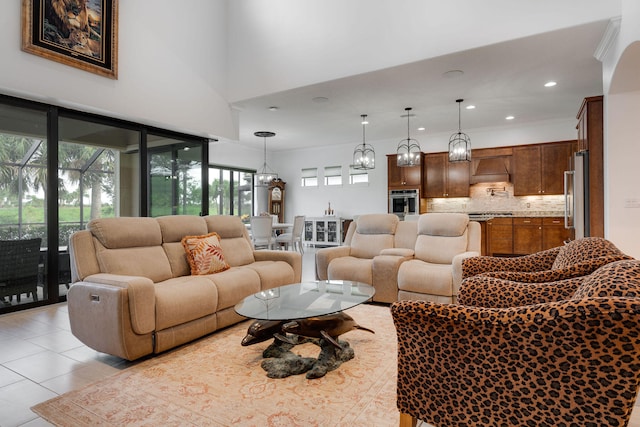 living room featuring light tile patterned floors, a high ceiling, and an inviting chandelier