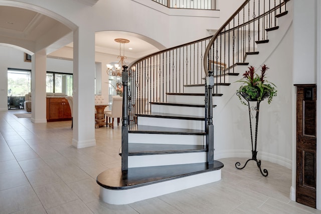 stairs featuring a chandelier, tile patterned floors, and ornamental molding