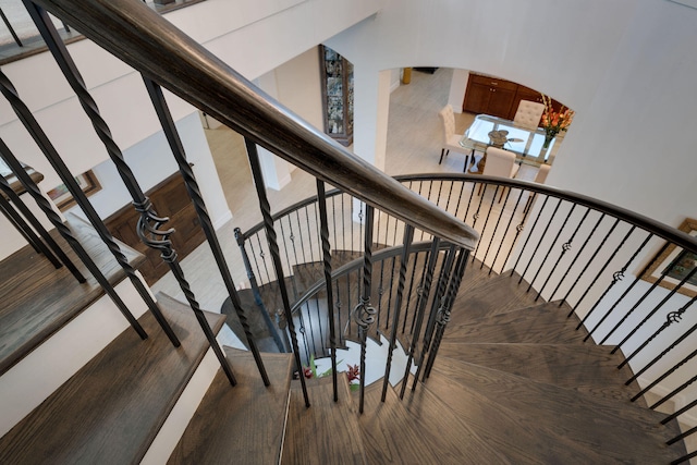 staircase featuring hardwood / wood-style floors and a towering ceiling