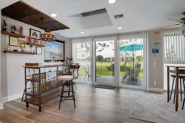 bar with light hardwood / wood-style floors and ceiling fan