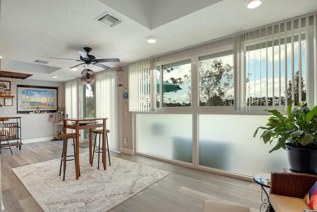 dining room with a textured ceiling, ceiling fan, and light hardwood / wood-style flooring