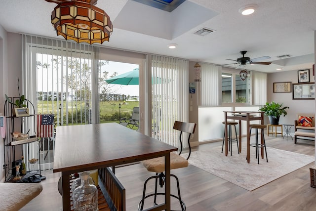 dining area featuring a textured ceiling, ceiling fan, and light wood-type flooring