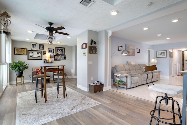 dining area featuring a textured ceiling, ceiling fan, and light hardwood / wood-style flooring