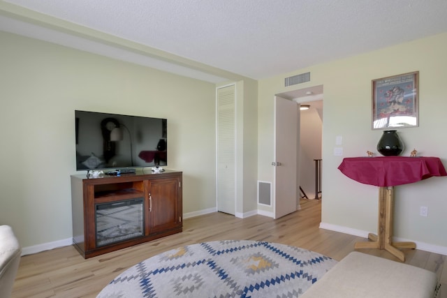 bedroom with a textured ceiling and light wood-type flooring