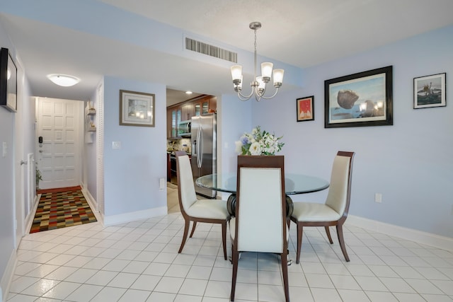 dining area featuring a notable chandelier and light tile floors