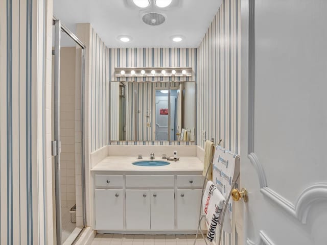 bathroom featuring vanity, tile flooring, and a shower with shower door