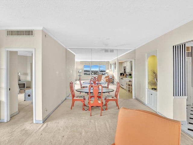 dining area featuring a textured ceiling, crown molding, and light colored carpet