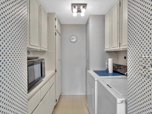 laundry room with light tile flooring, washing machine and dryer, and cabinets