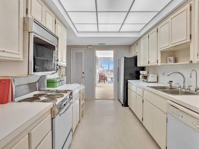 kitchen featuring light tile floors, white appliances, and sink