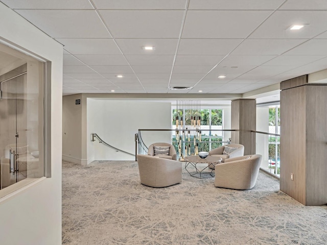 sitting room featuring a paneled ceiling and light colored carpet