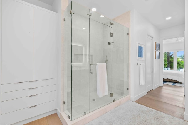 bathroom featuring an enclosed shower and hardwood / wood-style flooring