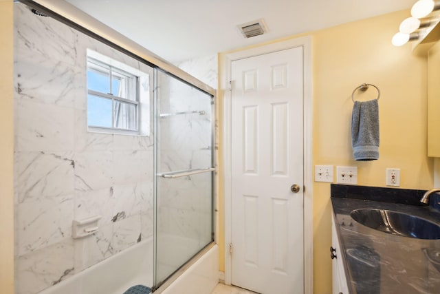 bathroom with vanity and combined bath / shower with glass door