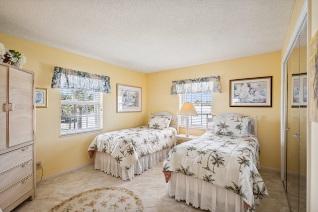 tiled bedroom featuring a textured ceiling