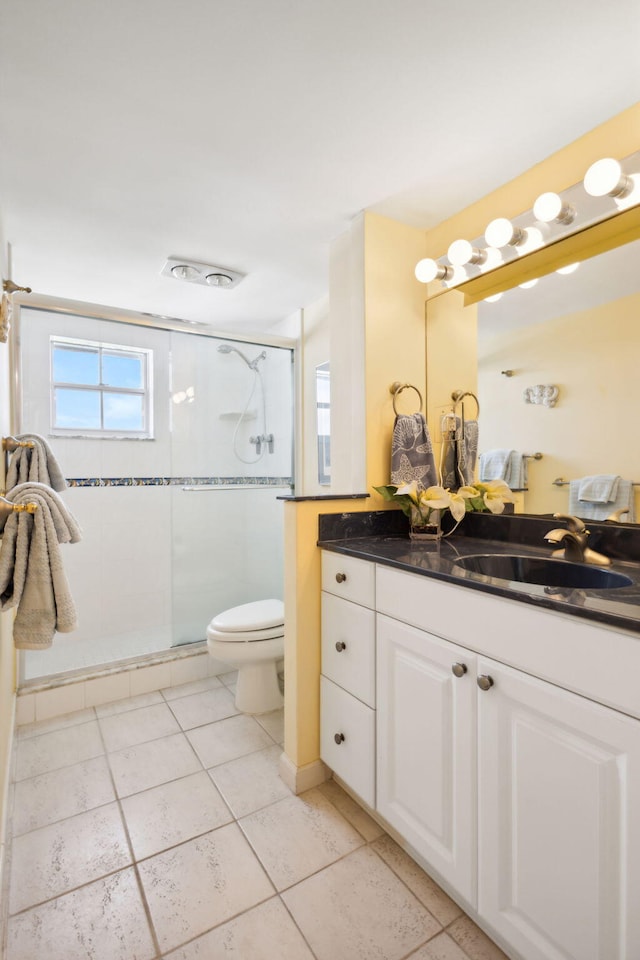 bathroom with vanity, a shower with door, and toilet