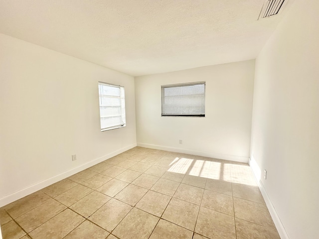 tiled spare room with a textured ceiling