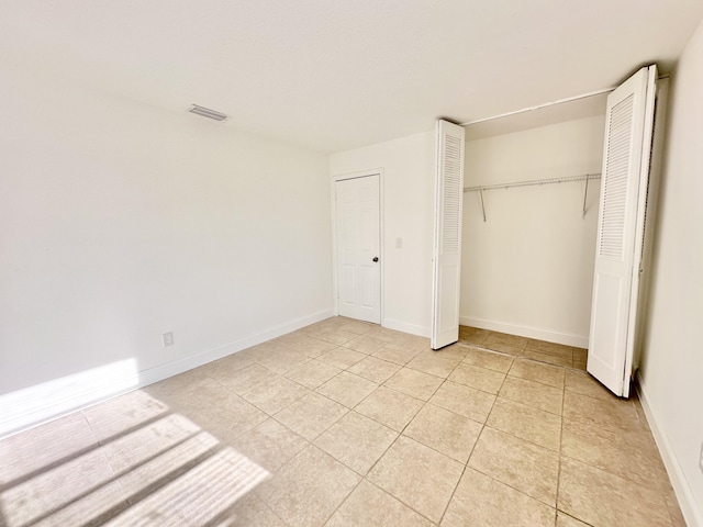 unfurnished bedroom with a closet and light tile flooring