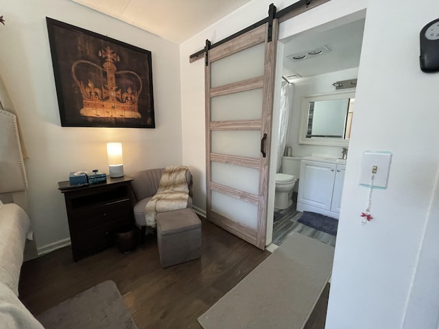 living area with a barn door and dark wood-type flooring