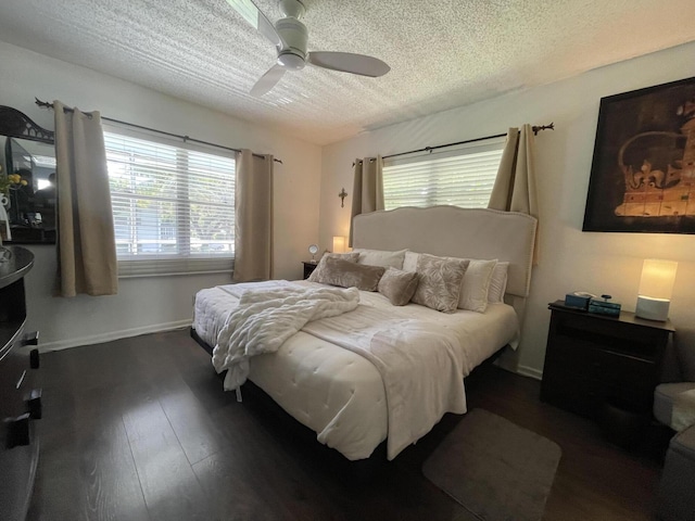 bedroom with ceiling fan, dark hardwood / wood-style flooring, and a textured ceiling