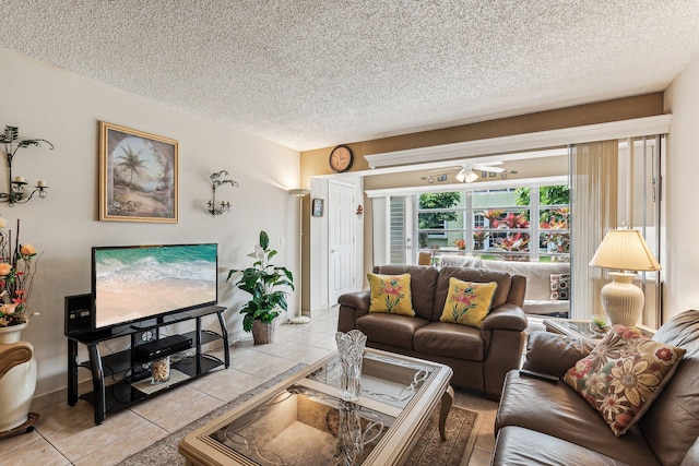 living room with ceiling fan, a textured ceiling, and light tile flooring