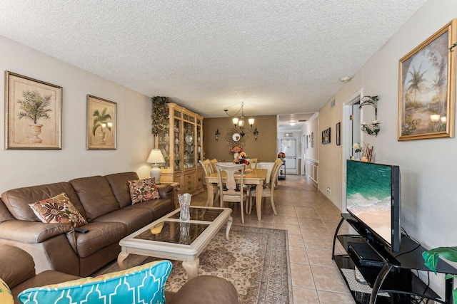 living room featuring tile floors, an inviting chandelier, and a textured ceiling