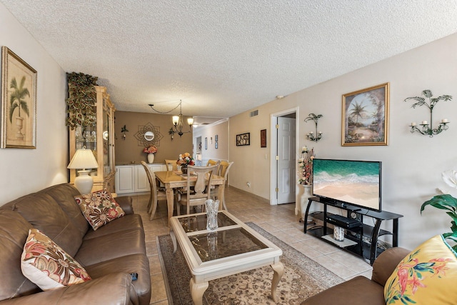 living room featuring a textured ceiling, light tile flooring, and a chandelier