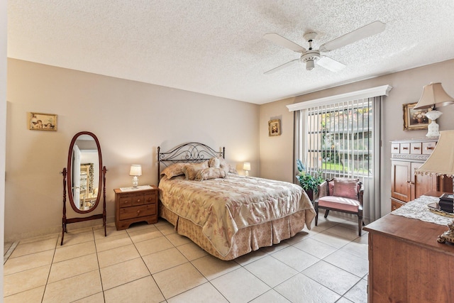 bedroom featuring ceiling fan, a textured ceiling, and light tile floors