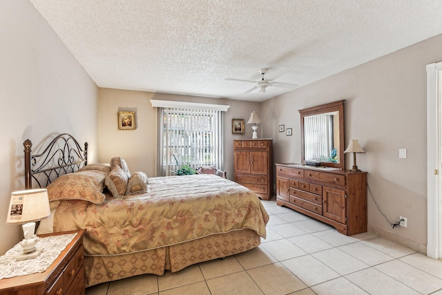 tiled bedroom with ceiling fan and a textured ceiling