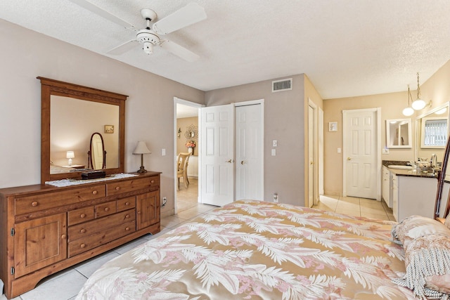 tiled bedroom with ceiling fan and a textured ceiling