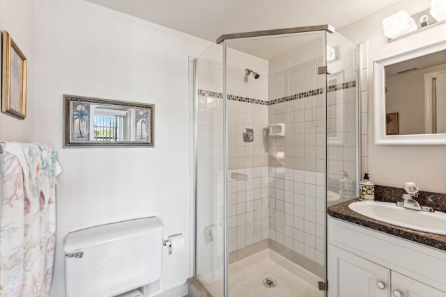 bathroom with a shower with shower door, vanity, and toilet