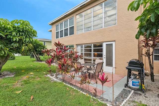 back of property featuring a patio and a lawn