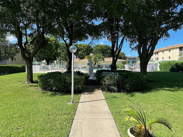 surrounding community with fence and a lawn