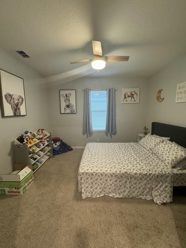 bedroom featuring vaulted ceiling, carpet flooring, ceiling fan, and a textured ceiling