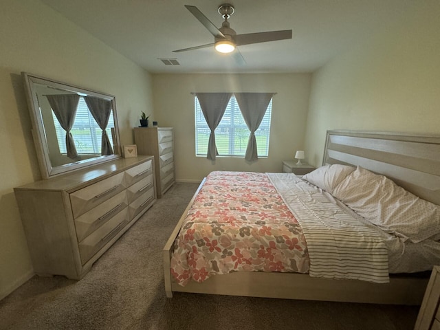 carpeted bedroom featuring ceiling fan and multiple windows