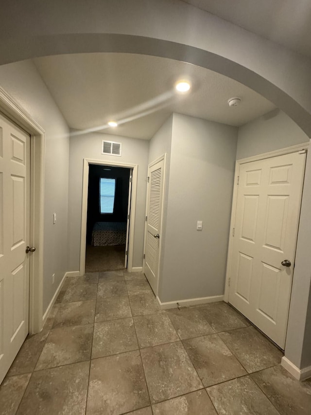 hallway with dark tile floors