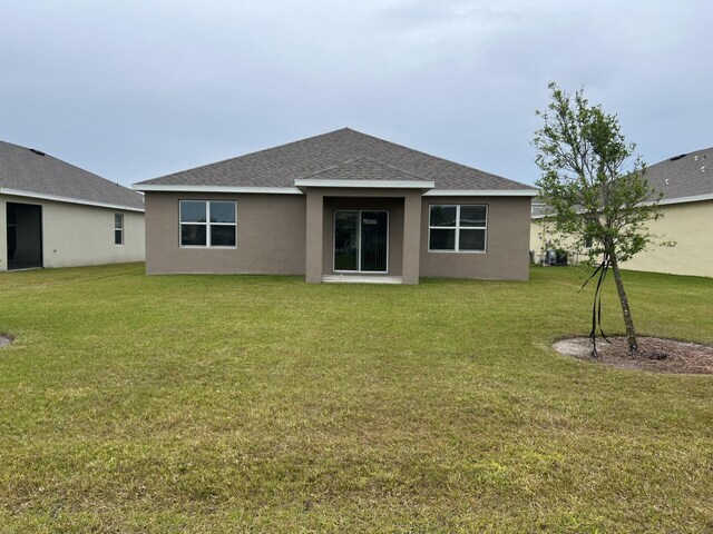 rear view of property featuring a yard