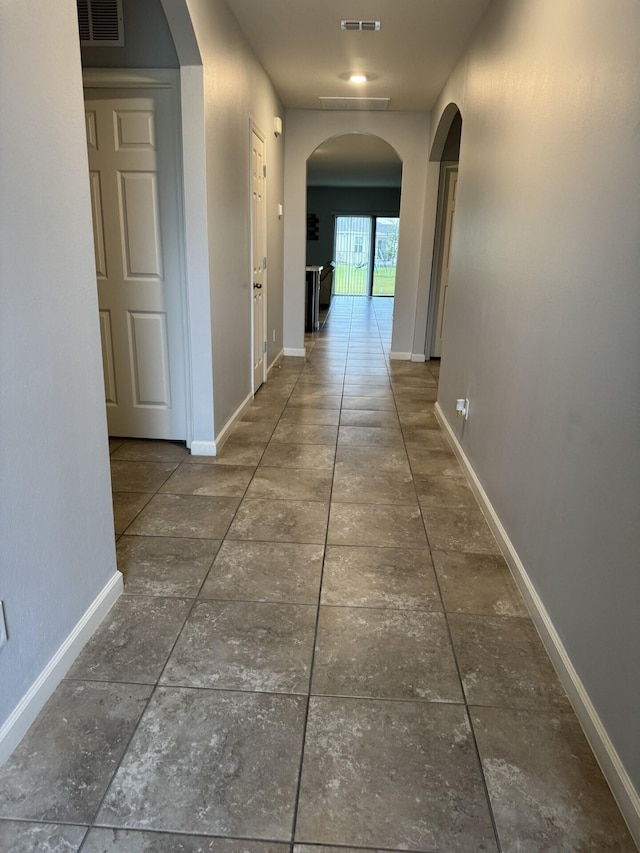 hallway with dark tile floors