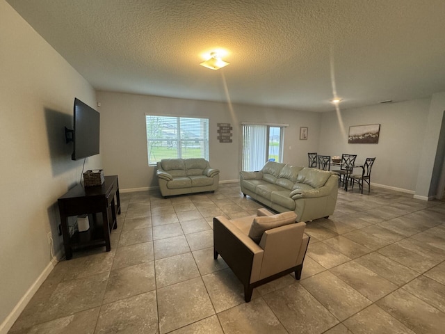 living room with light tile flooring and a textured ceiling