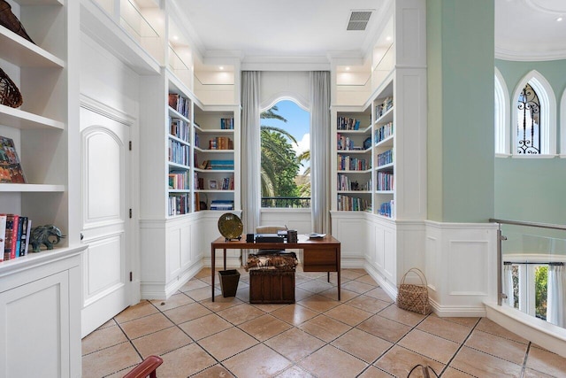 home office featuring crown molding, light tile flooring, and built in shelves